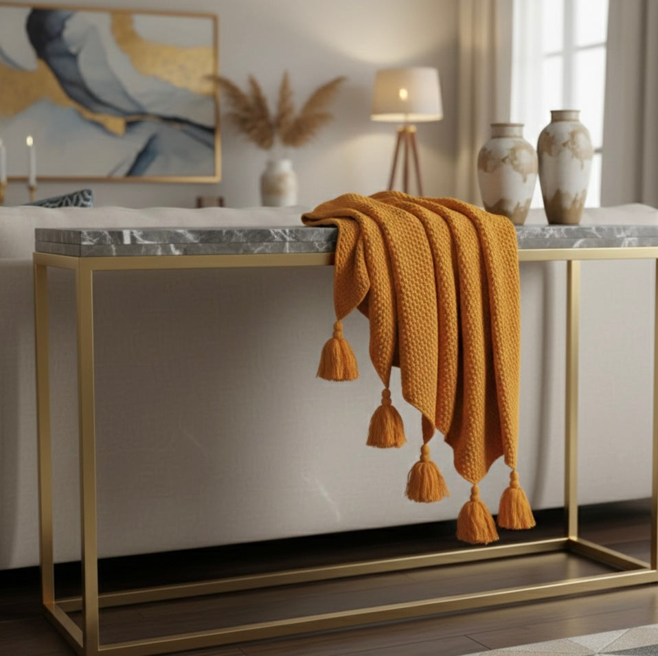 Gold console table with a marble top in a stylish room setting.