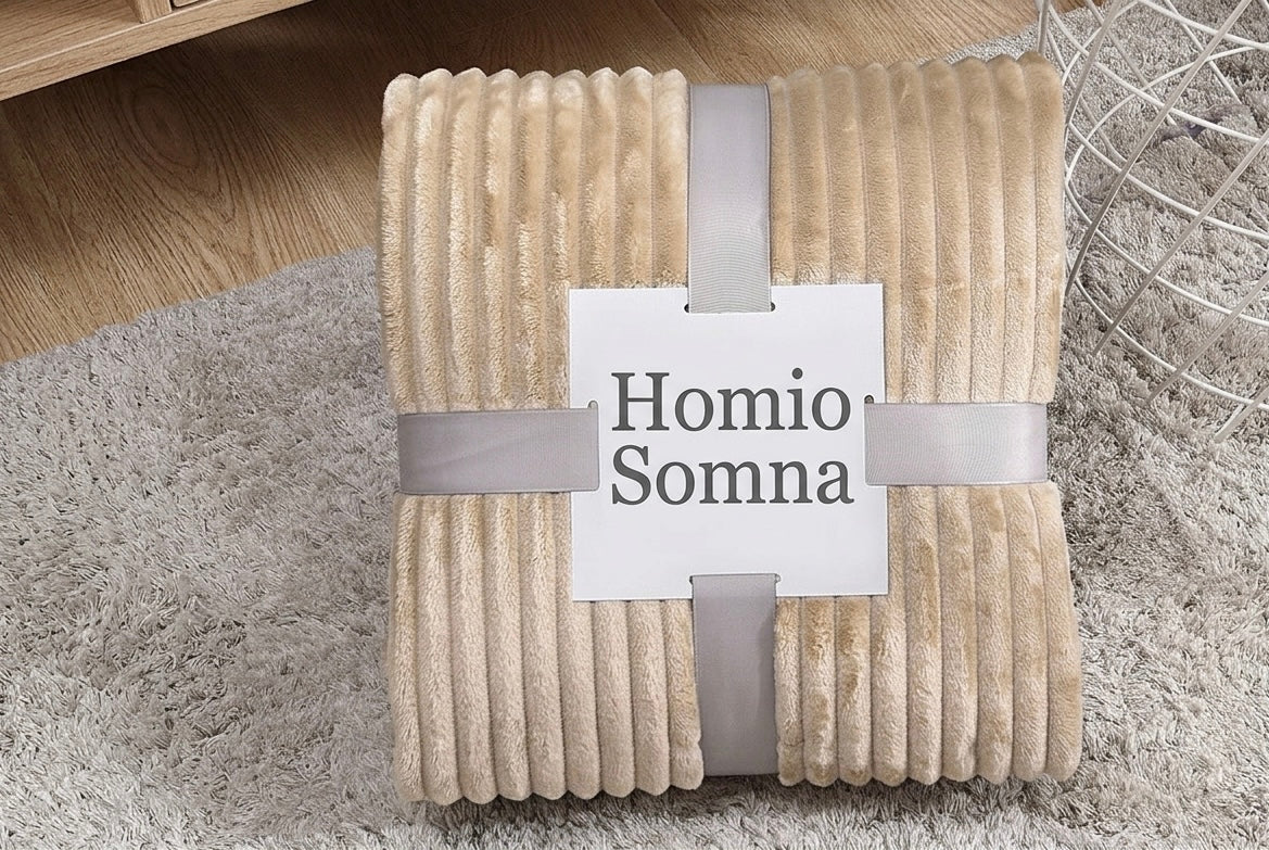 Beige blanket with 'Homio Somna' label on a textured surface