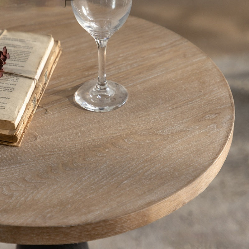Wooden table with a glass and an open book on a neutral background