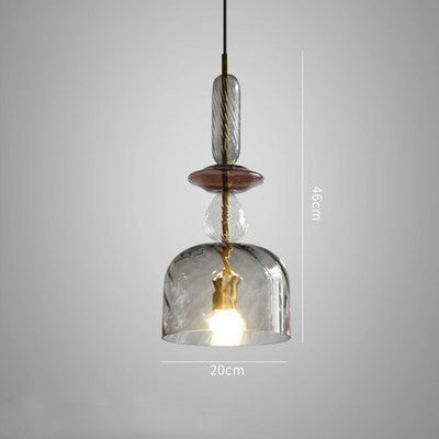 Glass pendant light with wooden base on a gray background