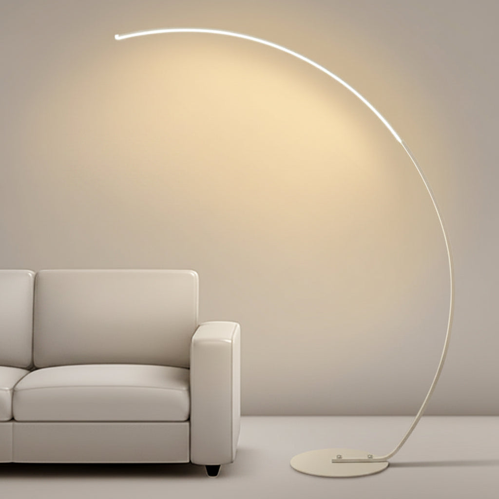 Modern floor lamp with a curved design next to a sofa in a minimalistic room.