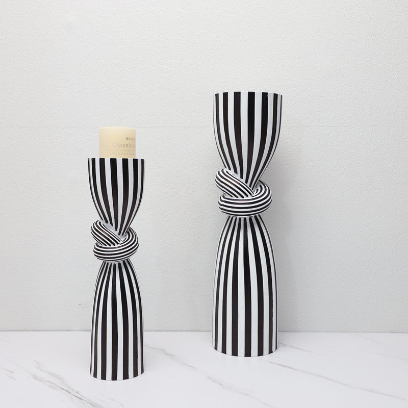 Black and white striped curtain tied in a knot against a white background