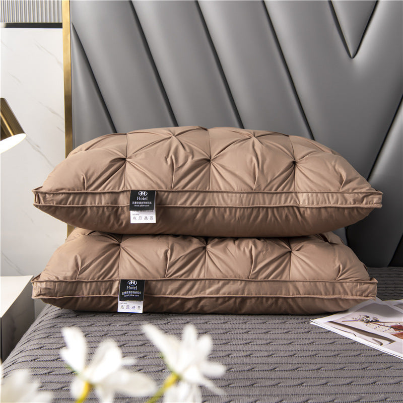 Two brown pillows stacked on a bed with a decorative headboard.
