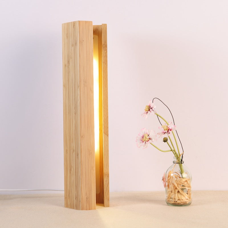 Wooden lamp with a vase of flowers on a light background