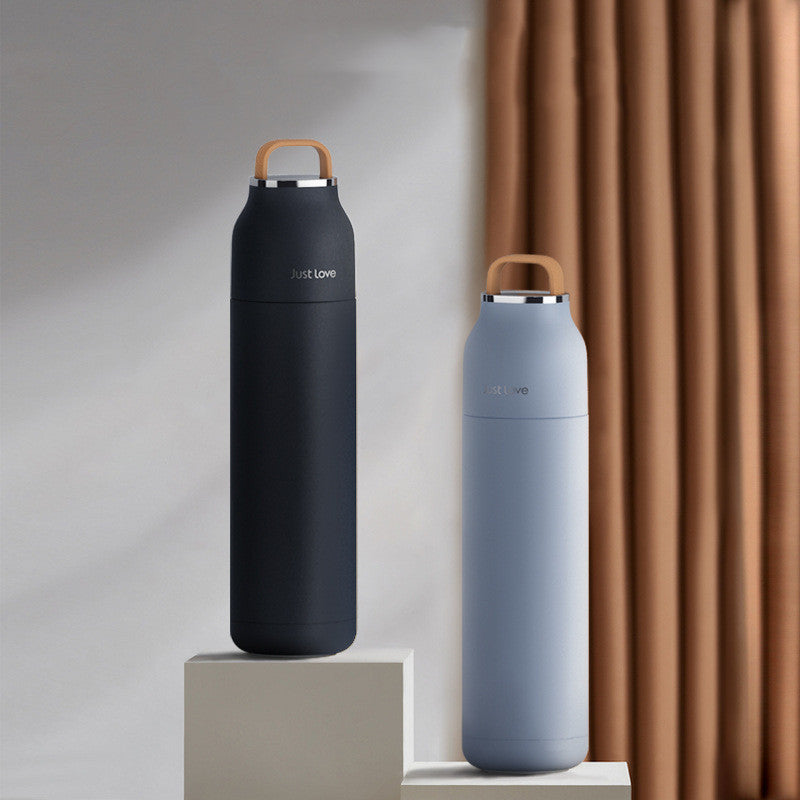Two insulated water bottles, one black and one gray, on a neutral background.