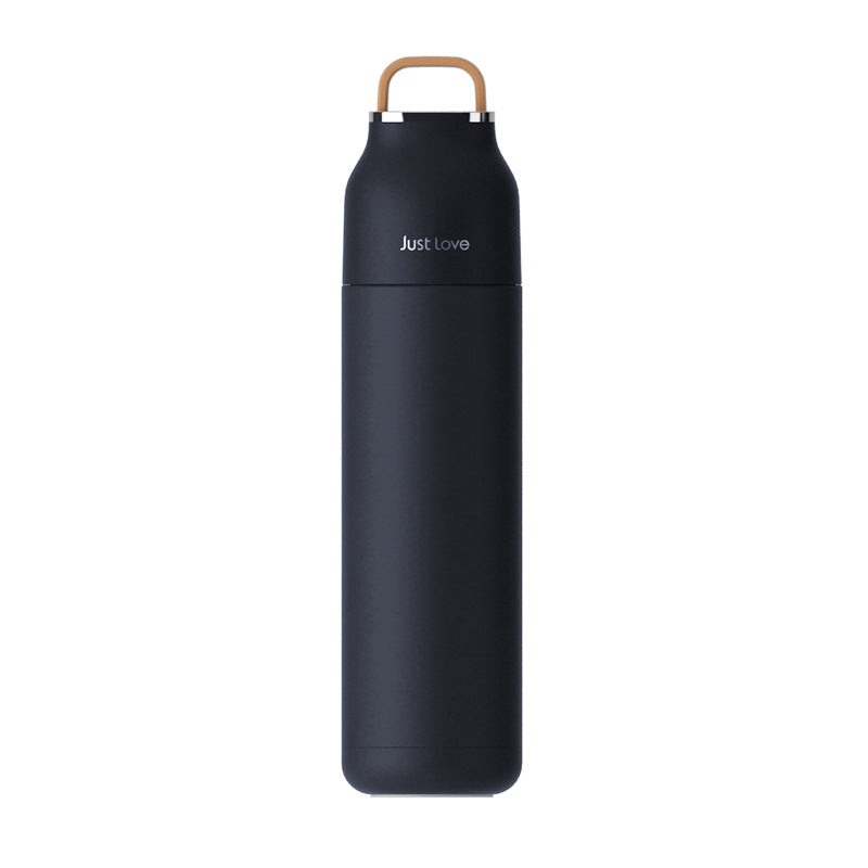 Black water bottle with wooden cap on a white background