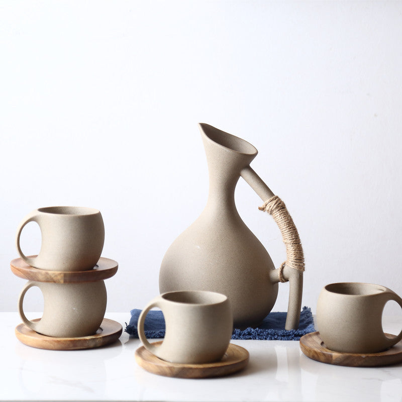 Set of ceramic cups and a pitcher on a white background