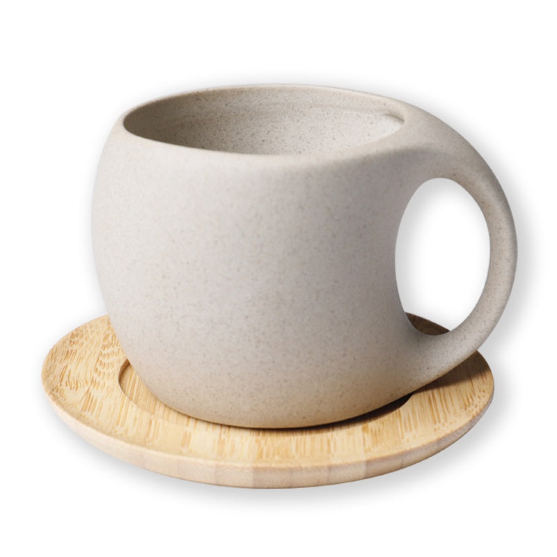 Beige ceramic mug on a wooden coaster with a white background