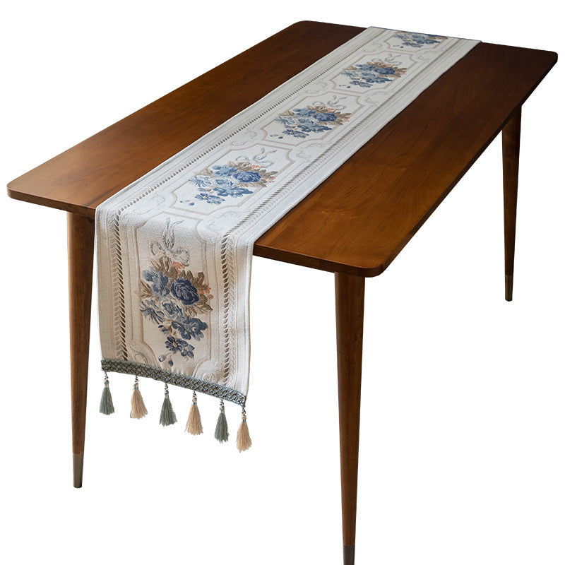 Wooden table with a decorative floral table runner on a white background