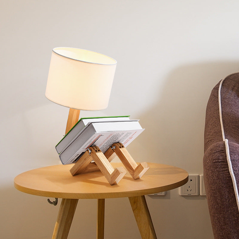 Small wooden table with a lamp and books on a neutral background