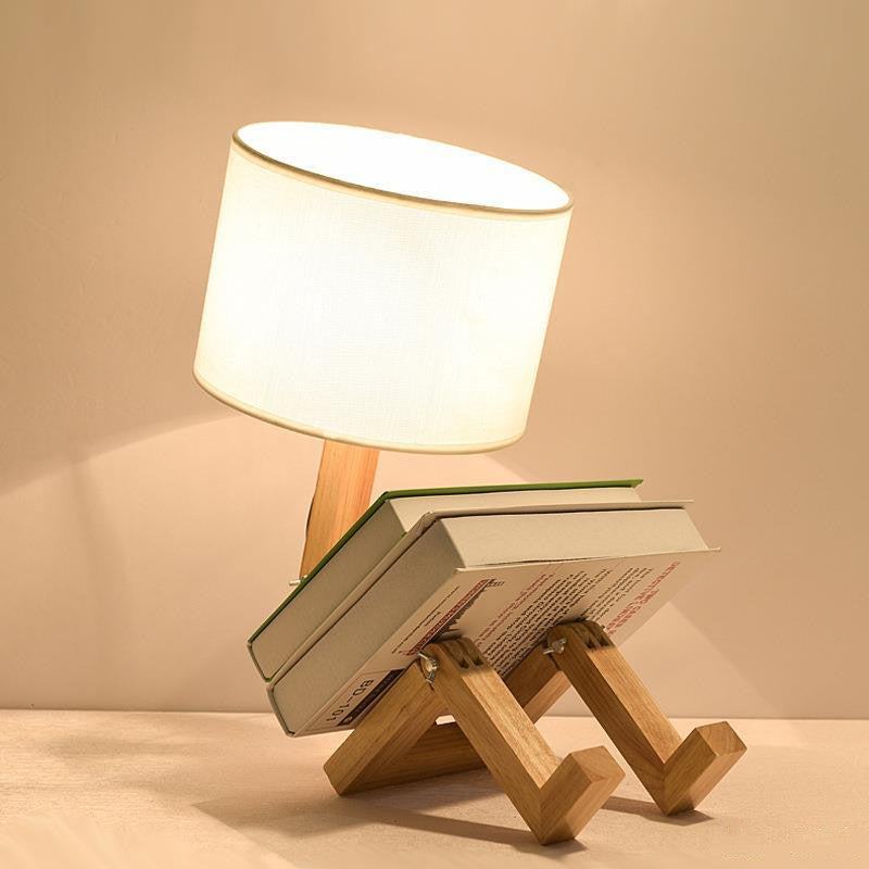 Wooden lamp with a fabric shade on top of books against a beige background