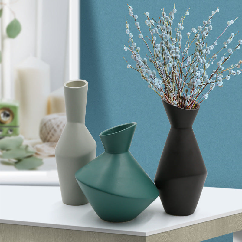 Three vases on a surface with a blue wall in the background