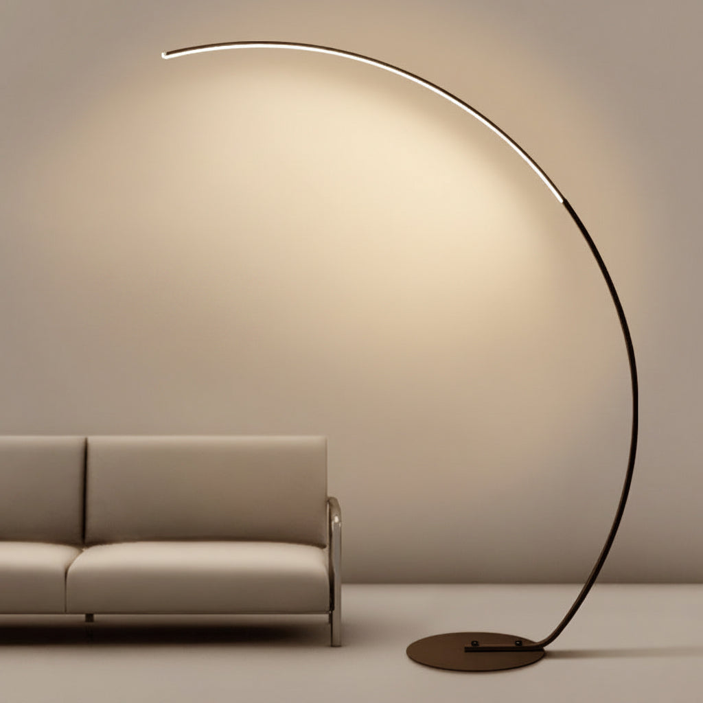 Modern floor lamp with a curved design next to a beige sofa against a neutral wall.