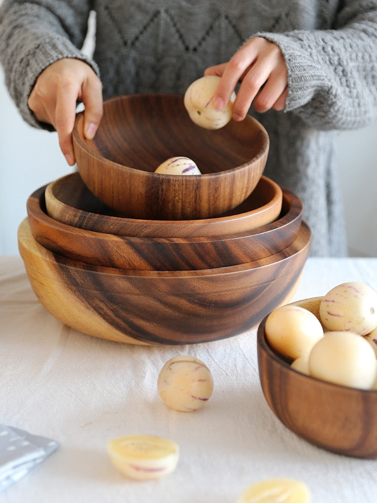 Stack of wooden bowls with eggs on a light surface