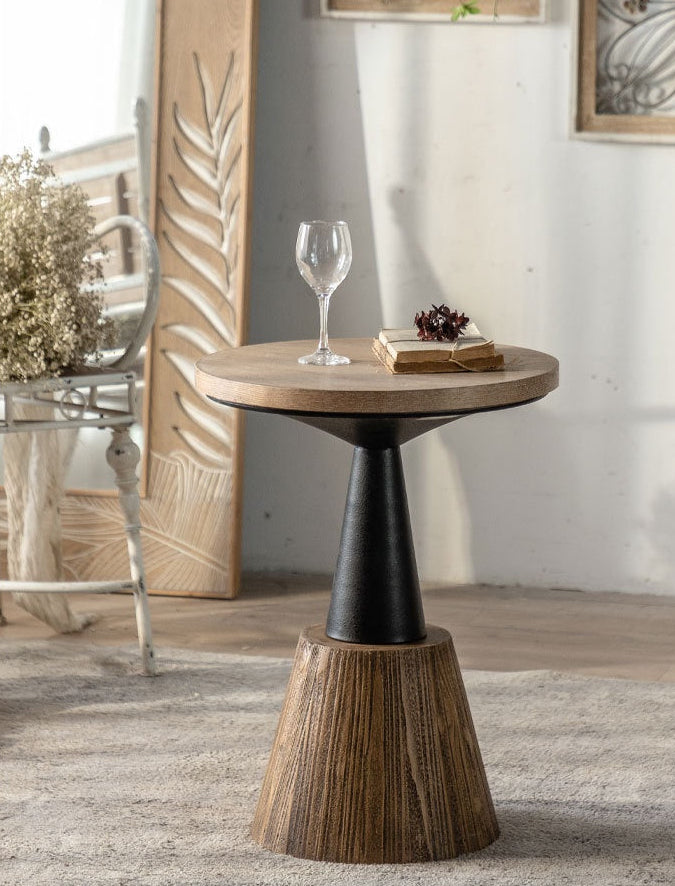 Wooden side table with a black pedestal base in a room setting.