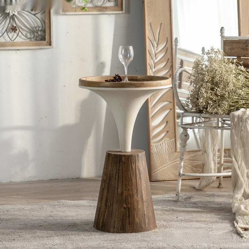 Wooden side table with a glass on top in a room setting