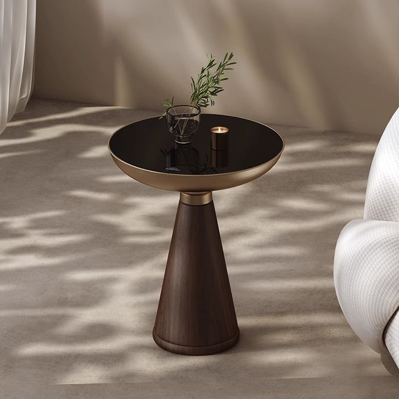 Modern side table with black top and bronze base in a minimalistic setting