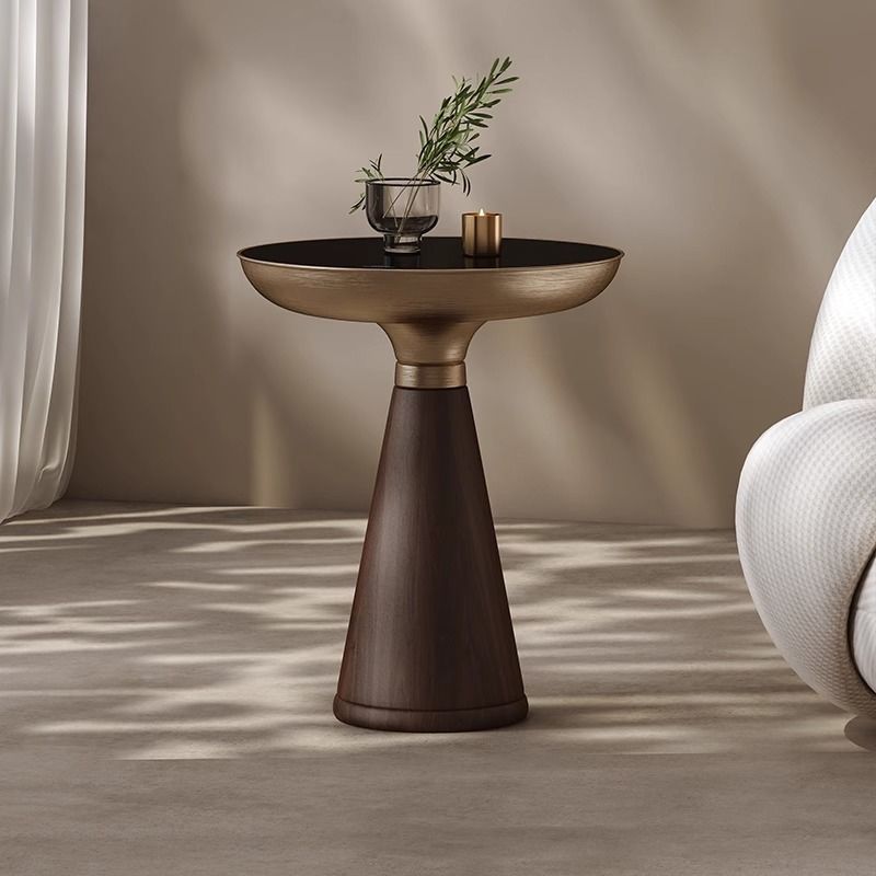 Bronze side table with decorative items against a neutral wall