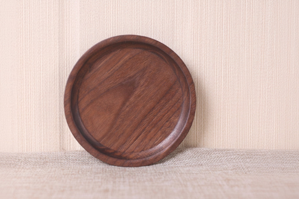 Wooden round tray on a textured surface with a neutral background