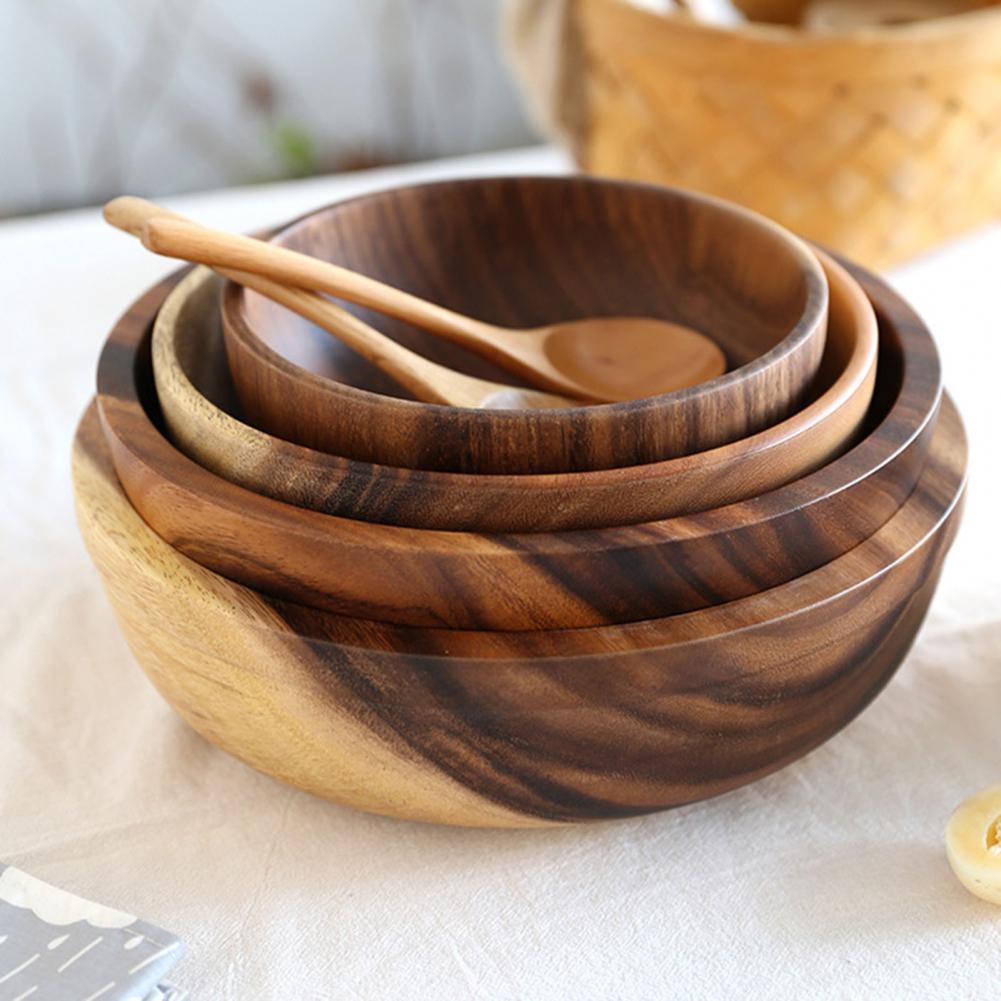 Set of wooden bowls with a spoon on a light surface