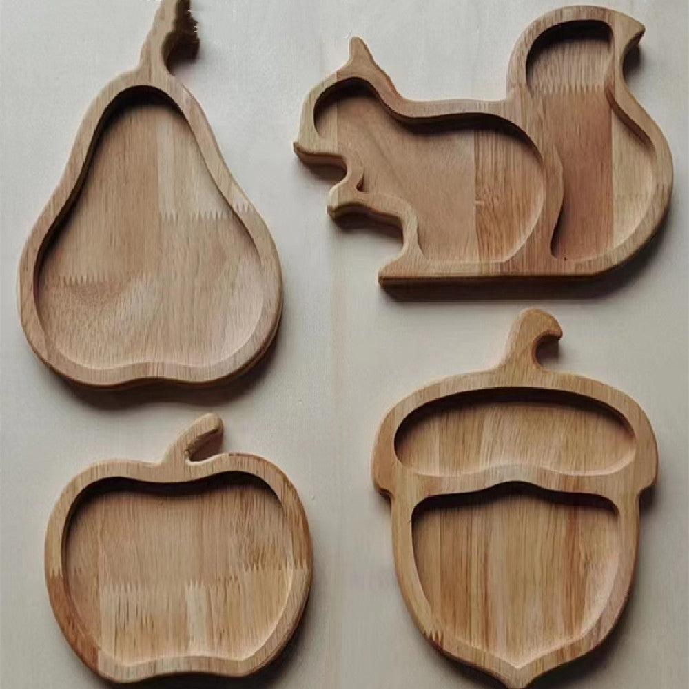 Four wooden trays shaped like a pear, squirrel, apple, and acorn on a light background.