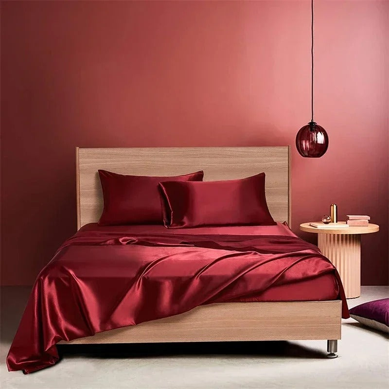 Bed with red satin bedding against a pink wall