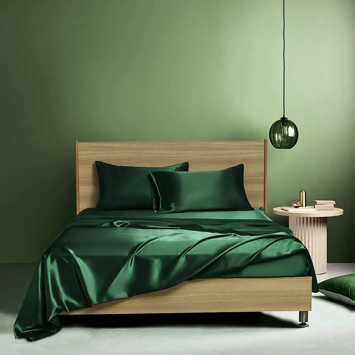 Bed with green satin bedding against a green wall