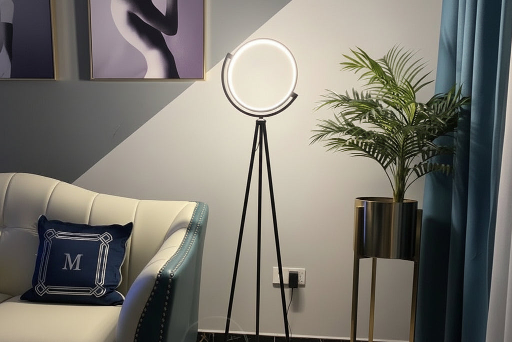 Modern floor lamp in a living room setting with a couch and plant.