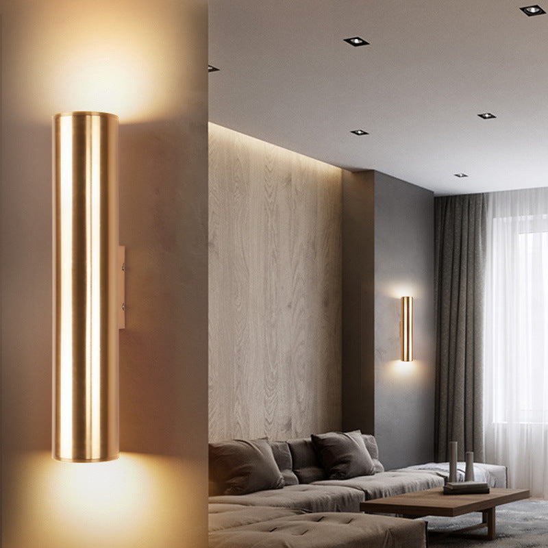 Modern living room with a cylindrical wall light fixture.