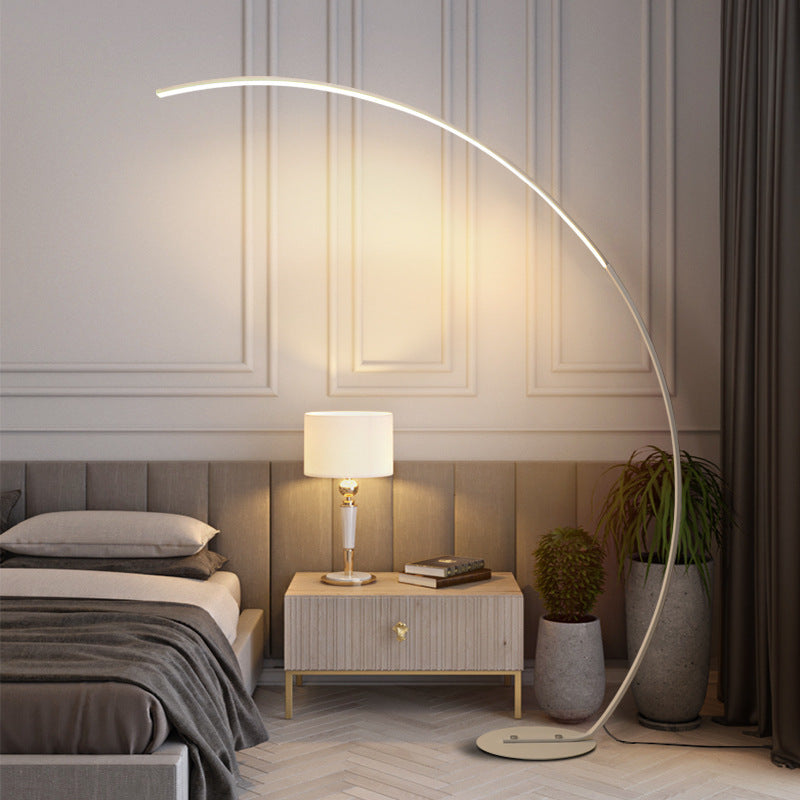 Modern bedroom with a large floor lamp, bed, nightstand, and decorative elements.