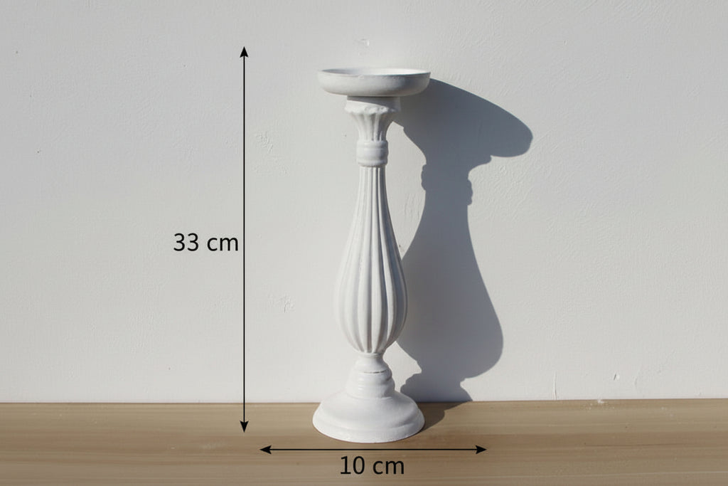 White decorative pedestal on a wooden surface with a plain white background