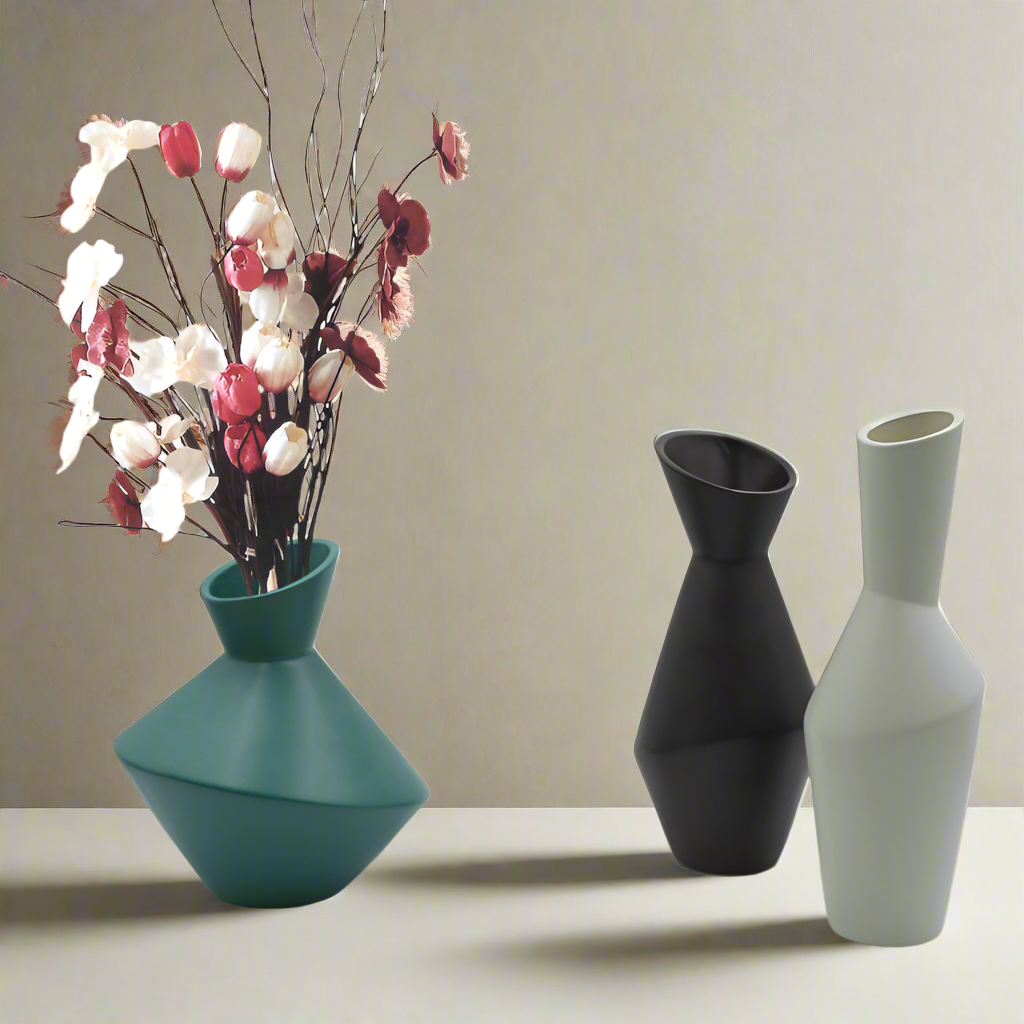 Three vases of different colors (teal, black, gray) with floral arrangement on a neutral background