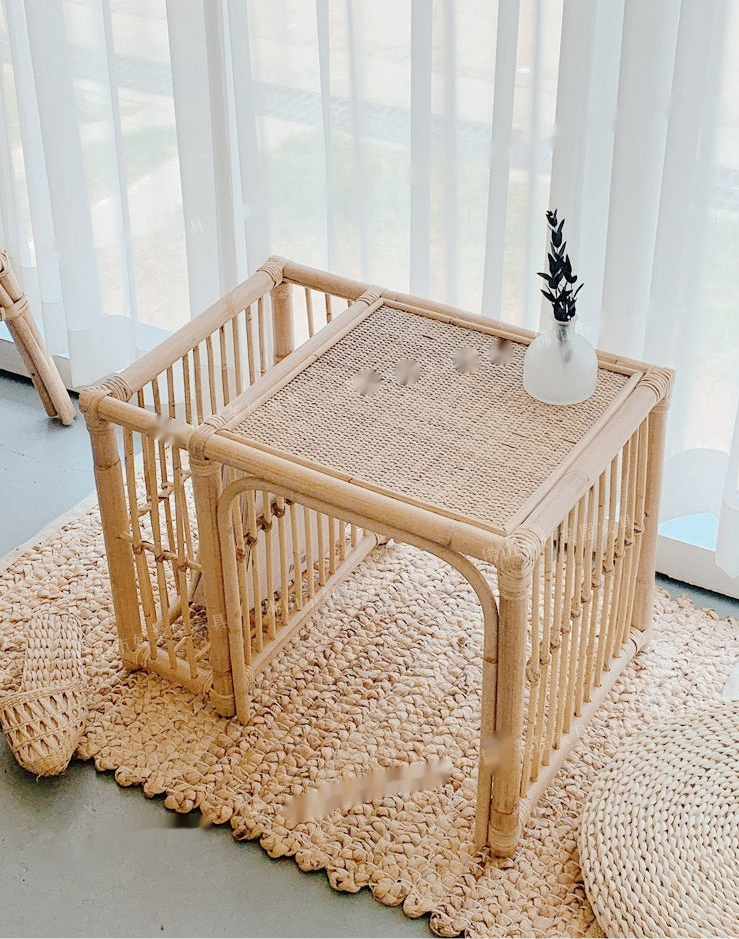 Wicker side table with a textured surface in a room with light curtains.