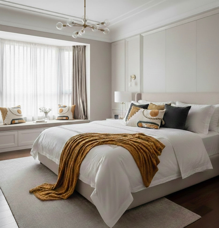 Modern bedroom with a bed, pillows, and a window seat.