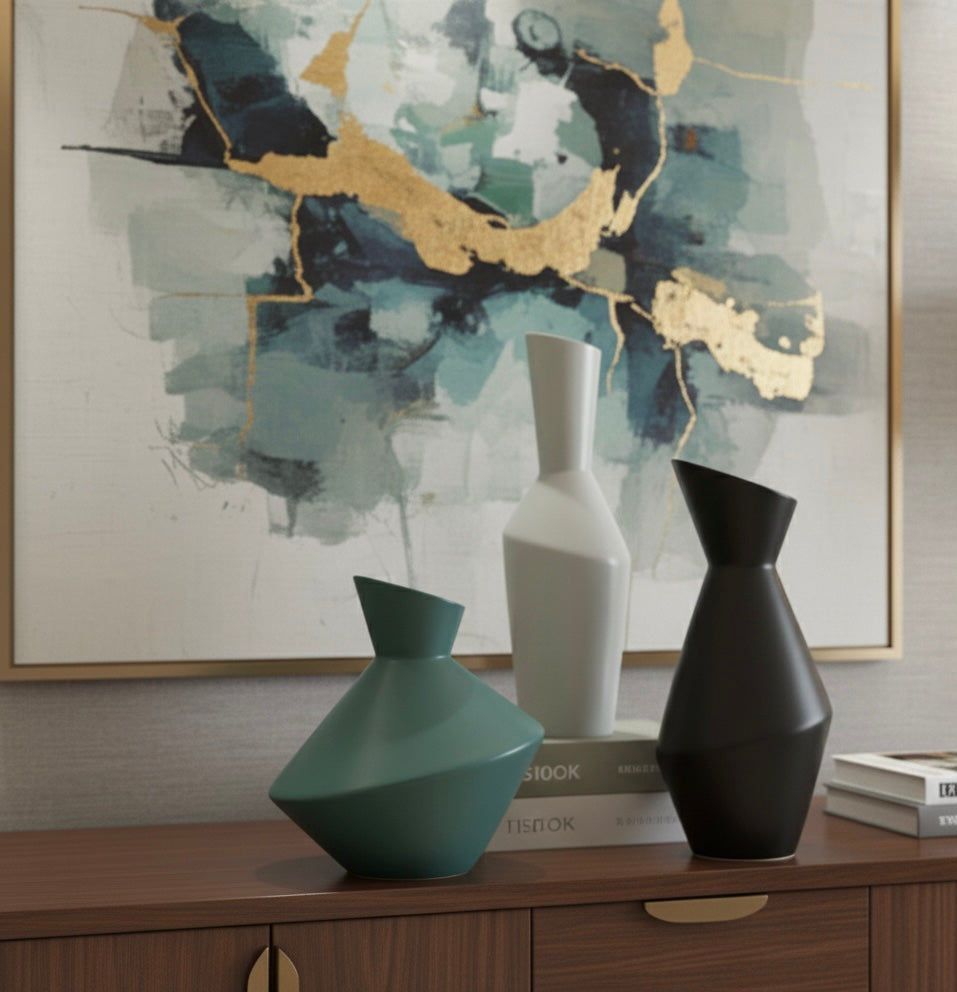 Three vases on a wooden surface with abstract art in the background