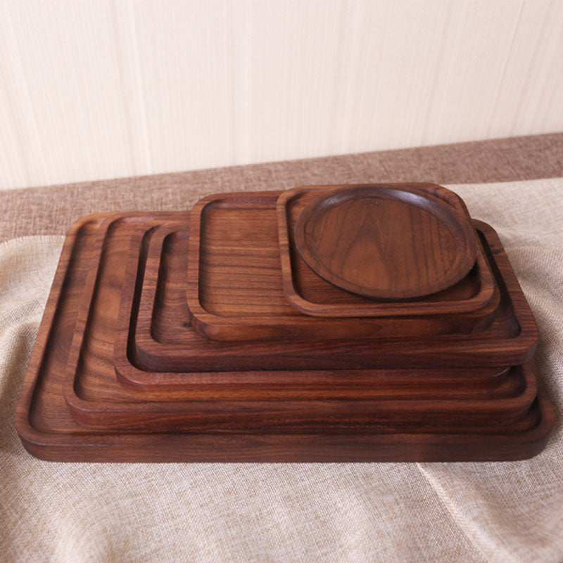 Set of wooden trays of different sizes on a textured surface