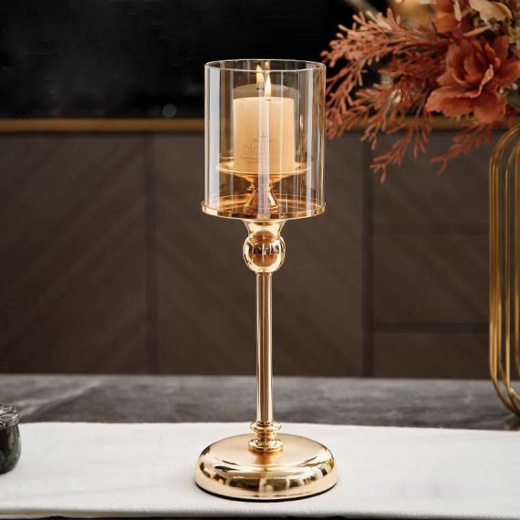 Gold candle holder with a candle on a marble surface, with a blurred background