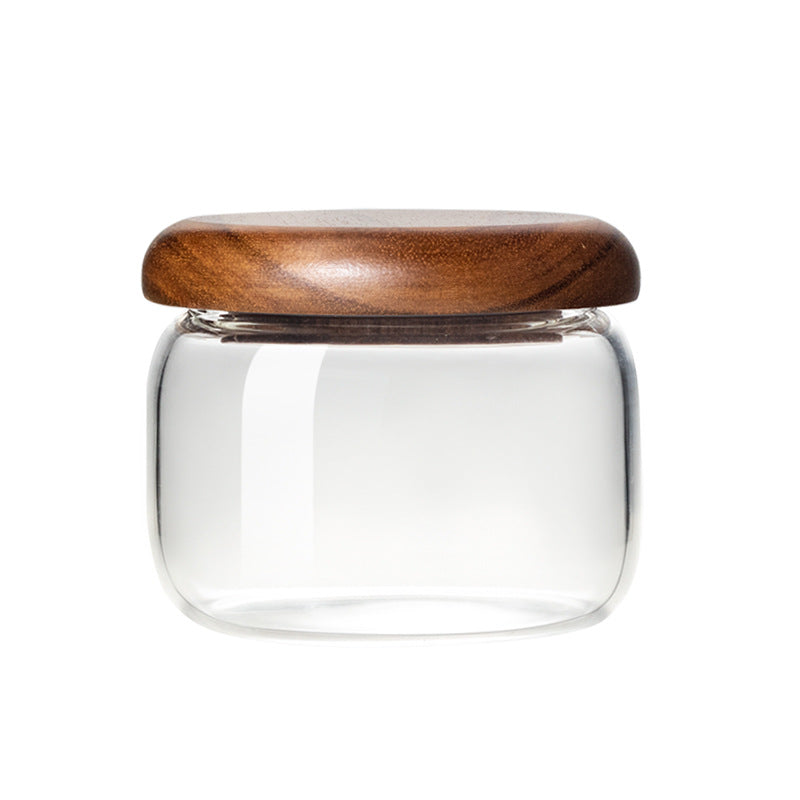 Clear glass jar with a wooden lid on a white background