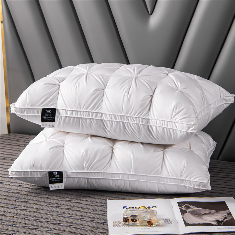 Two white pillows stacked on a bed with an open magazine underneath.
