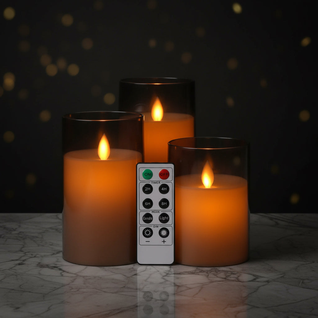 Set of three smoked glass candles with flame and a remote control on a white background