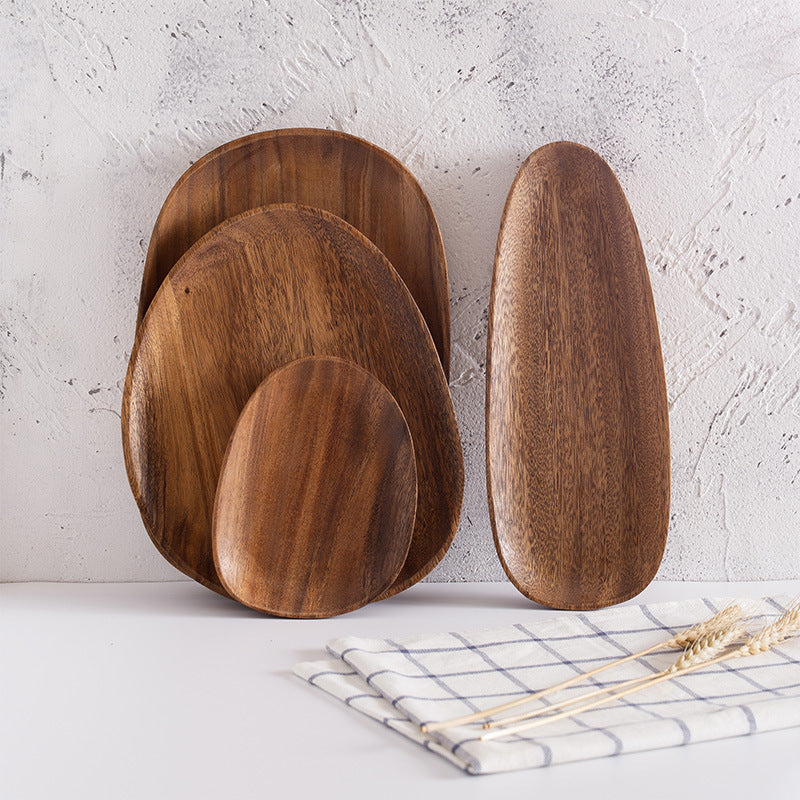 Set of wooden serving platters on a light surface with a neutral background